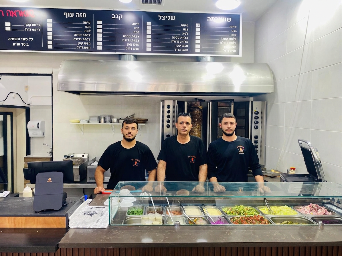 הצוות של שווארמה רונן, רונן, גד ועומרי מאחורי הדלפק בחוצות אלונים